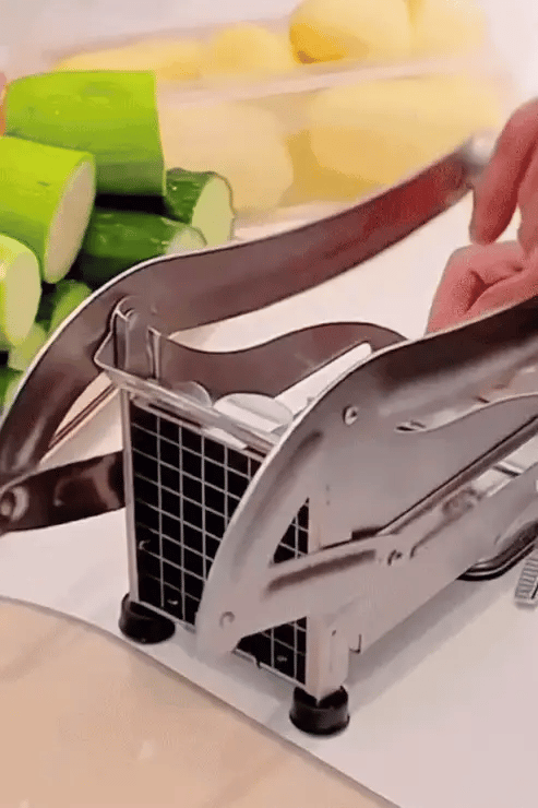 Manual vegetable chopper with vegetables on a cutting board