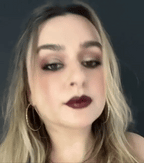 Close-up of a person with dark hair and makeup against a dark background. Emiravlay uae
