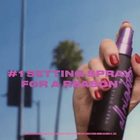 Hand holding a setting spray with text overlay against a blue sky background Emiravaly uae