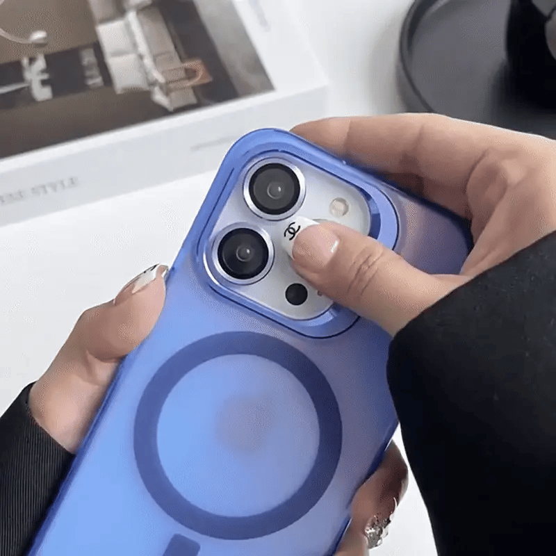 Person holding a phone with a blue case, blurred background Emiravaly