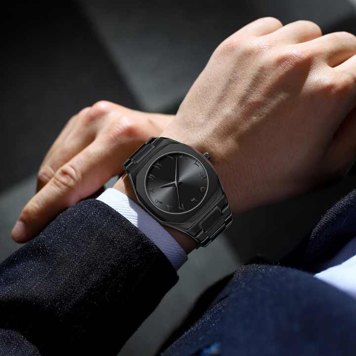 Person wearing a black smartwatch on a dark background