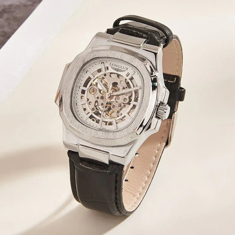 Silver watch with black leather strap on a light background